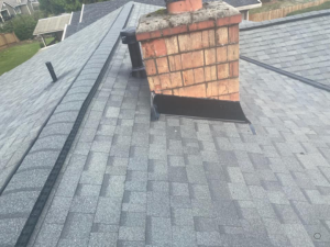 Roofing professional inspecting shingles on a residential roof in Kent.