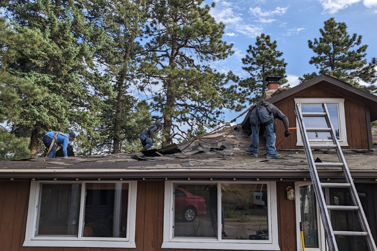 Roofing team removing old shingles on an Auburn home