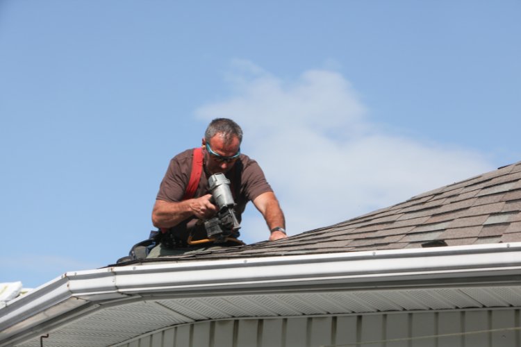 Roofing professional performing maintenance on a Puyallup home